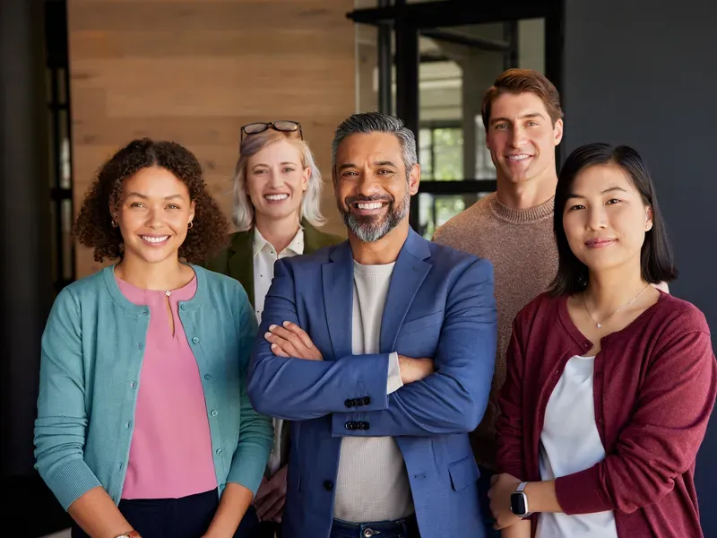 Diverse corporate team smiling in an office setting, ideal for business directory profile
